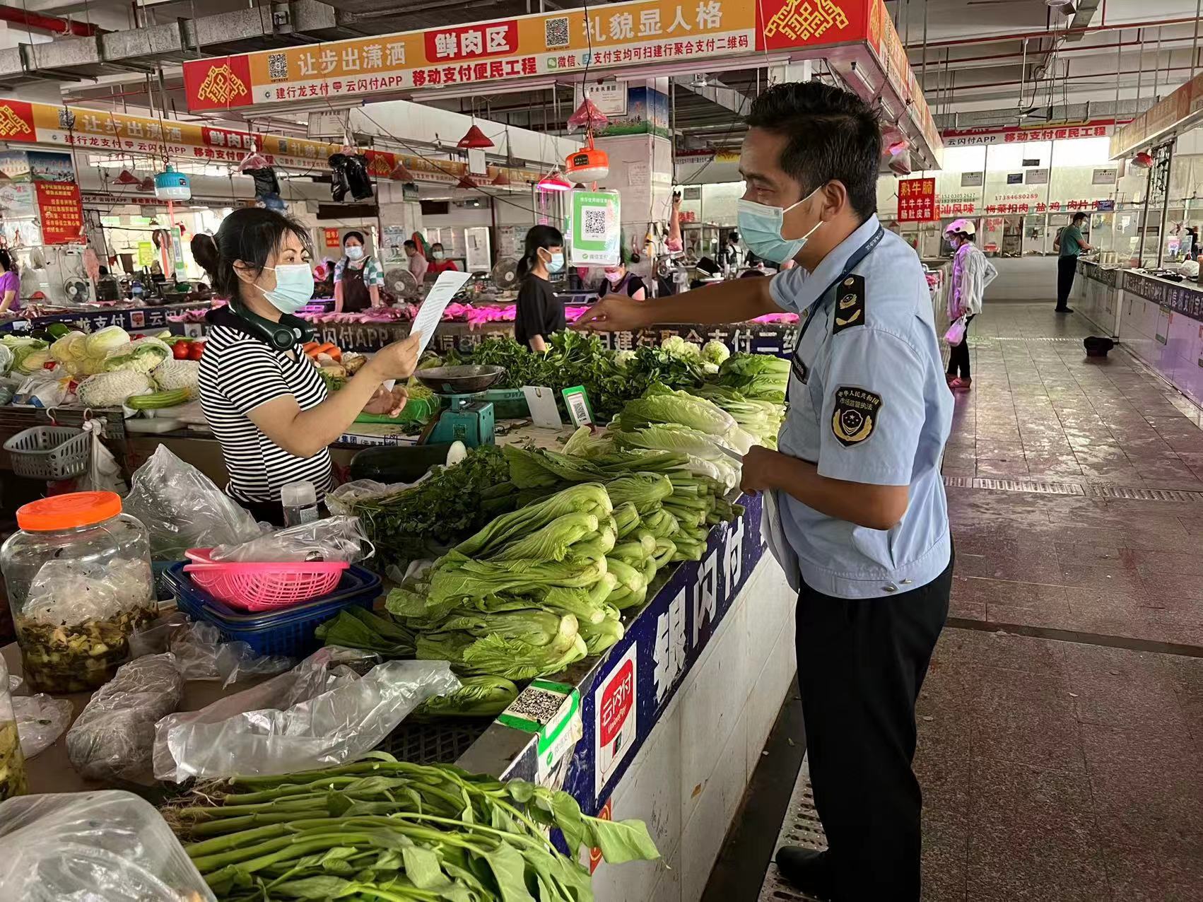 执法人员向市场摊贩发放规范价格行为告诫书.jpg